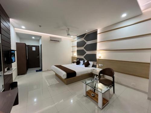 a bedroom with a bed and a tv in a room at Hotel Grand Darshan Vadodara in Vadodara