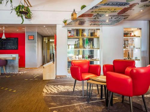 a restaurant with red chairs and a table at ibis Colmar Est - Hotel Restaurant en Alsace in Colmar