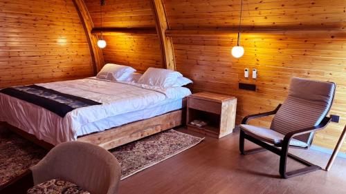 1 dormitorio con 1 cama y 1 silla en una cabaña en Serengeti Ark Safari Lodge - Kogatende, en Parque Nacional del Serengeti