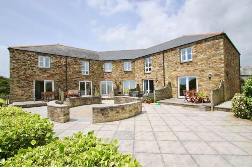 an exterior view of a brick house with a patio at Two Bedroomed Holiday Cottage with Sea Views in St Austell