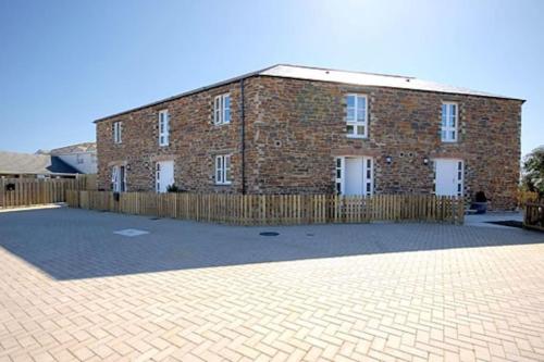 un edificio di mattoni con una recinzione di fronte di Two Bedroomed Holiday Cottage with Sea Views a St Austell