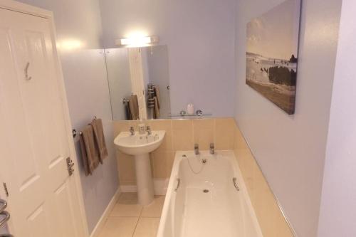 a bathroom with a sink and a bath tub at Two Bedroomed Holiday Cottage with Sea Views in St Austell