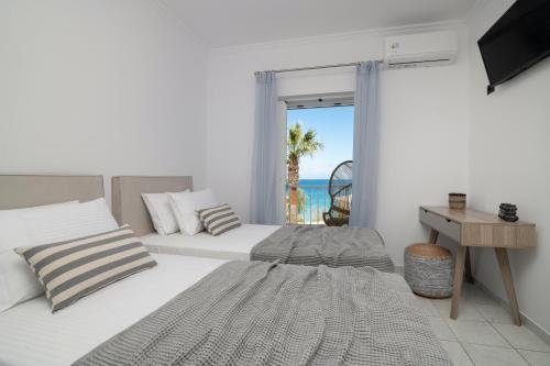 a bedroom with two beds and a view of the ocean at Swan Apartments in Zakynthos