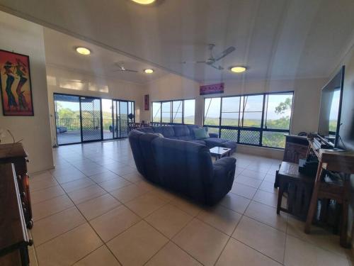 a large living room with a couch and a television at Sit back, relax and enjoy the view in Agnes Water