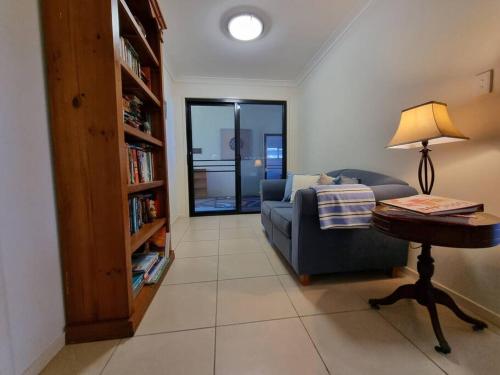 a living room with a couch and a table with a lamp at Sit back, relax and enjoy the view in Agnes Water