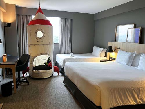 una habitación de hotel con 2 camas y una torre de reloj en Pullman Sao Paulo Guarulhos Airport, en Guarulhos