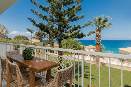 a table on a balcony with a view of the ocean at Swan Apartments in Zakynthos Town