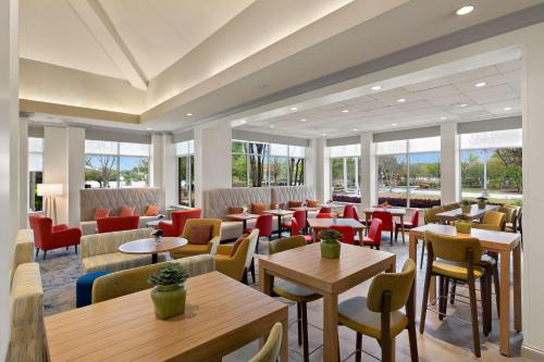 a restaurant with tables and chairs and windows at Hilton Garden Inn Atlanta East/Stonecrest in Lithonia