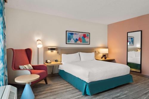 a hotel room with a bed and a chair at Hilton Garden Inn Atlanta East/Stonecrest in Lithonia