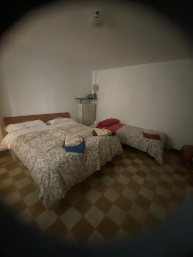 a bedroom with two beds and a checkered floor at I nespoli in Imola