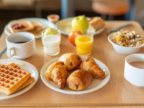 a table topped with plates of breakfast foods and drinks at ibis budget Mâcon Nord in Mâcon