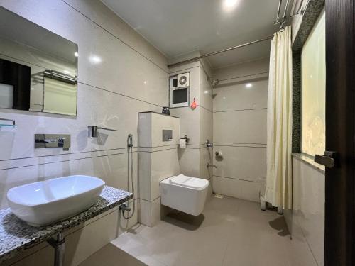 巴罗达Hotel Grand Darshan Vadodara的带水槽和马桶的白色浴室