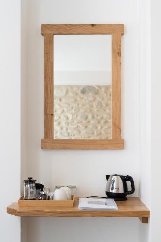 a mirror hanging on a wall above a shelf at La Barule in Charols