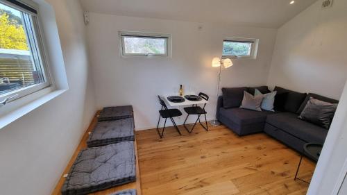 a living room with a couch and a table at Beach-near cozy cottage in Höllviken