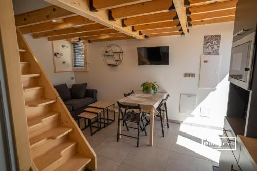 - une cuisine et une salle à manger avec une table et des escaliers dans l'établissement Maison rénovée et climatisée avec WIFI à 600m de la plage, à Vias