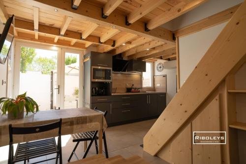 Il comprend une cuisine avec des plafonds en bois, une table et des chaises. dans l'établissement Maison rénovée et climatisée avec WIFI à 600m de la plage, à Vias