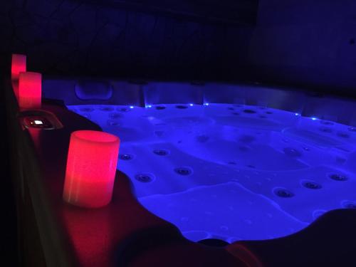 a dark room with a tub with a red candle at Wellness Hotel Várfal in Pécs