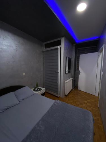 a bedroom with a bed and a blue light at Play Apartman Obrenovac in Obrenovac