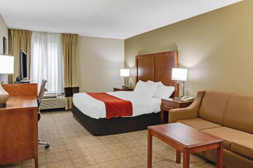 a hotel room with a bed and a couch at Comfort Inn in Henderson