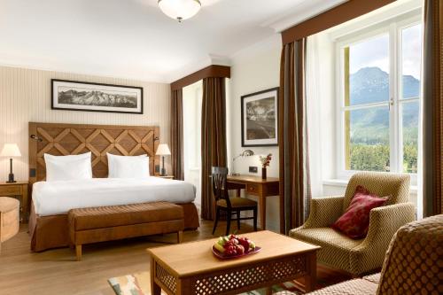 a hotel room with a bed and a desk and chair at Grand Hotel Kempinski High Tatras in Štrbské Pleso