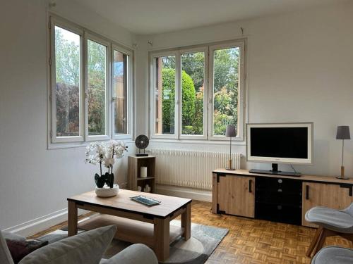un salon avec une télévision et une table basse dans l'établissement Appart - proche gare - 4 pers, à Vaucresson