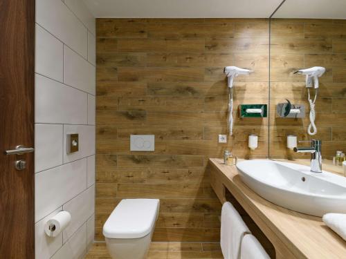 uma casa de banho com um lavatório e um WC em ibis Styles Aschaffenburg em Aschaffenburg