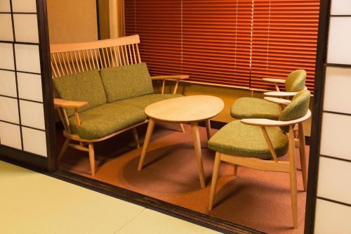 a mirror reflection of a chair and two chairs and a table at Ryokan Asunaro in Takayama