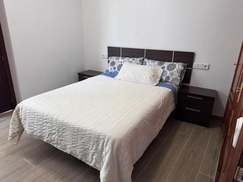 a bedroom with a large bed and two night stands at Atico padre Aldama centro y con WIFI in Sanlúcar de Barrameda
