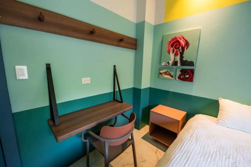 a bedroom with a bed and a desk in it at Marala Hotel in Esterillos