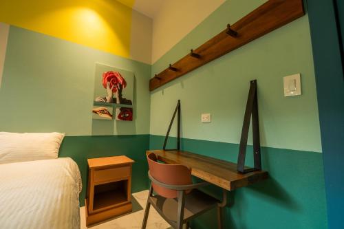 a bedroom with a desk and a bed and a bed and a desk at Marala Hotel in Esterillos