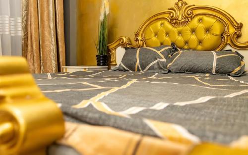 a bed with a gold headboard and pillows on it at Central Apartment ressidence city in Bucharest