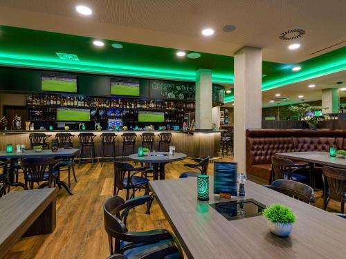 a restaurant with tables and chairs and a bar at Aparthotel Adagio Access Kiel in Kiel
