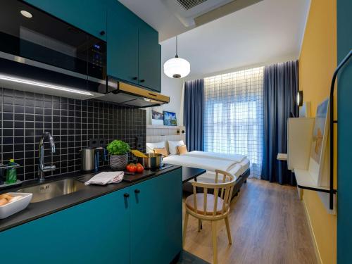 una cocina con fregadero y una cama en una habitación en Aparthotel Adagio Access Kiel en Kiel