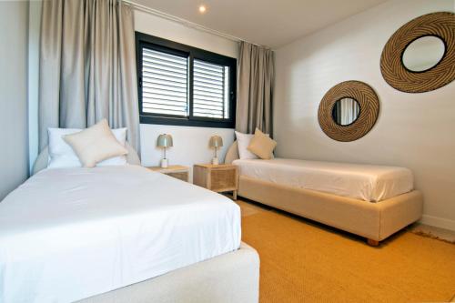 Un dormitorio con dos camas y un espejo. en Mara's Apartments Higuerón West - Nordic Style - Sunny Terrace, en Fuengirola