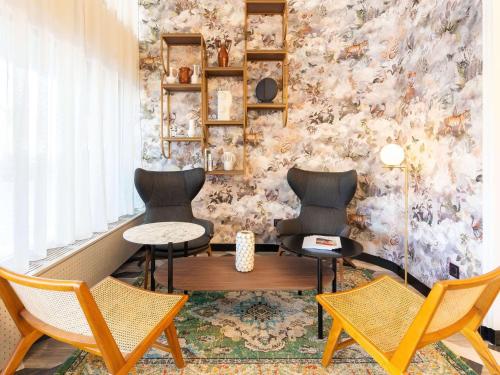 duas cadeiras e uma mesa num quarto com uma parede em Le Splendid Hotel Lac D'Annecy - Handwritten Collection em Annecy