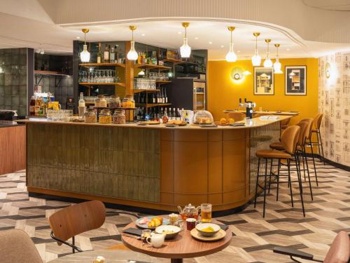 un bar en un restaurante con mesas y sillas en Le Splendid Hotel Lac D'Annecy - Handwritten Collection en Annecy