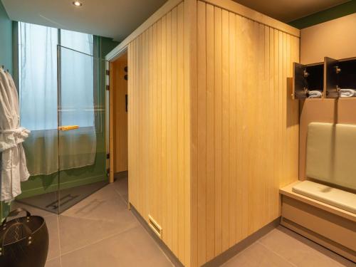 La salle de bains est pourvue de murs en bois et d'une douche en verre. dans l'établissement Le Splendid Hotel Lac D'Annecy - Handwritten Collection, à Annecy