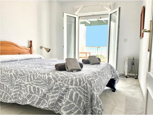sypialnia z łóżkiem i dwiema poduszkami w obiekcie Santa Barbara B Beach front with terrace, sea view in and garage in Conil w mieście Conil de la Frontera