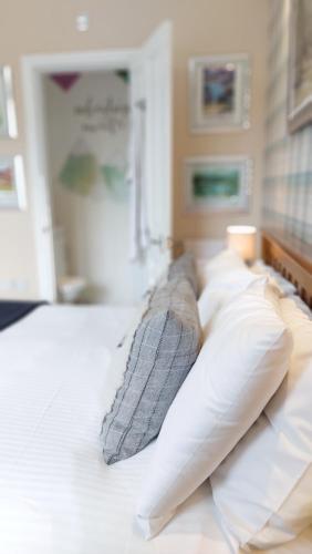 a bed with white pillows and a blanket at Invergarry Room Only Guest House For Adults in Windermere