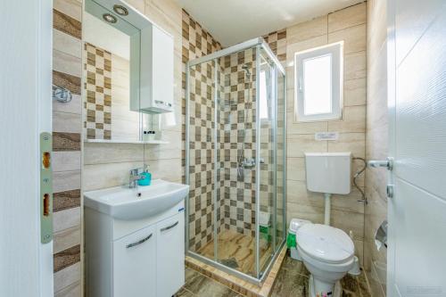 a bathroom with a toilet and a sink and a shower at Villa Tesla in Ohrid
