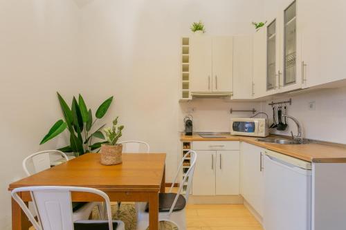 a kitchen with white cabinets and a wooden table at Templo cota 2330m in Sierra Nevada