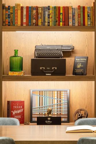 a book shelf with books and a printer on it at Doubletree By Hilton Abilene Downtown Convention Center in Abilene