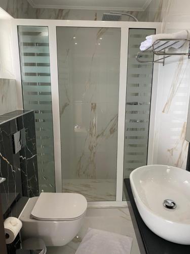 a bathroom with a shower and a toilet and a sink at Selefkos Palace in Igoumenitsa