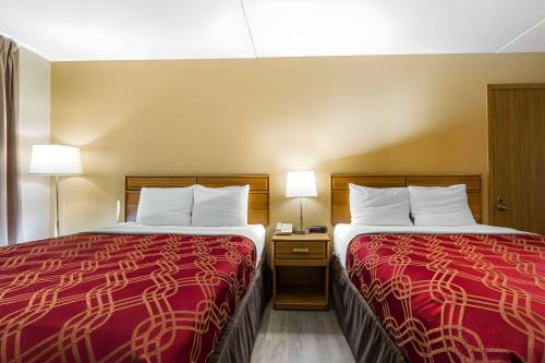 dos camas sentadas una al lado de la otra en una habitación de hotel en Ramada by Wyndham Branson Theatre District en Branson