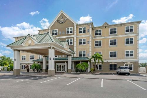 a large building with a car parked in a parking lot at Country Inn & Suites by Radisson, Tampa Airport North, FL in Tampa