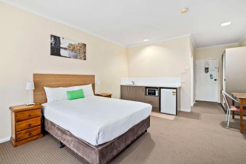a hotel room with a large bed and a kitchen at Comfort Inn Bishops Lodge in Hay