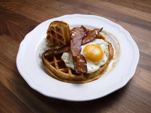a plate of breakfast food with eggs bacon and waffles at Do Dee cafe in Bangkok