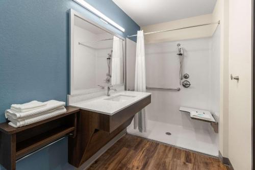 La salle de bains est pourvue d'un lavabo et d'un miroir. dans l'établissement WoodSpring Suites Bowling Green I-65, à Bowling Green