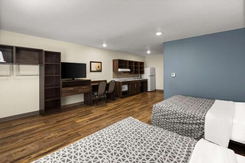a hotel room with a bed and a desk at WoodSpring Suites Bowling Green I-65 in Bowling Green