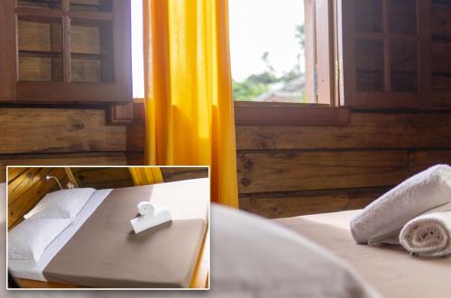 um quarto com uma cama com toalhas e uma janela em Lodge Garden em Saint-Pierre